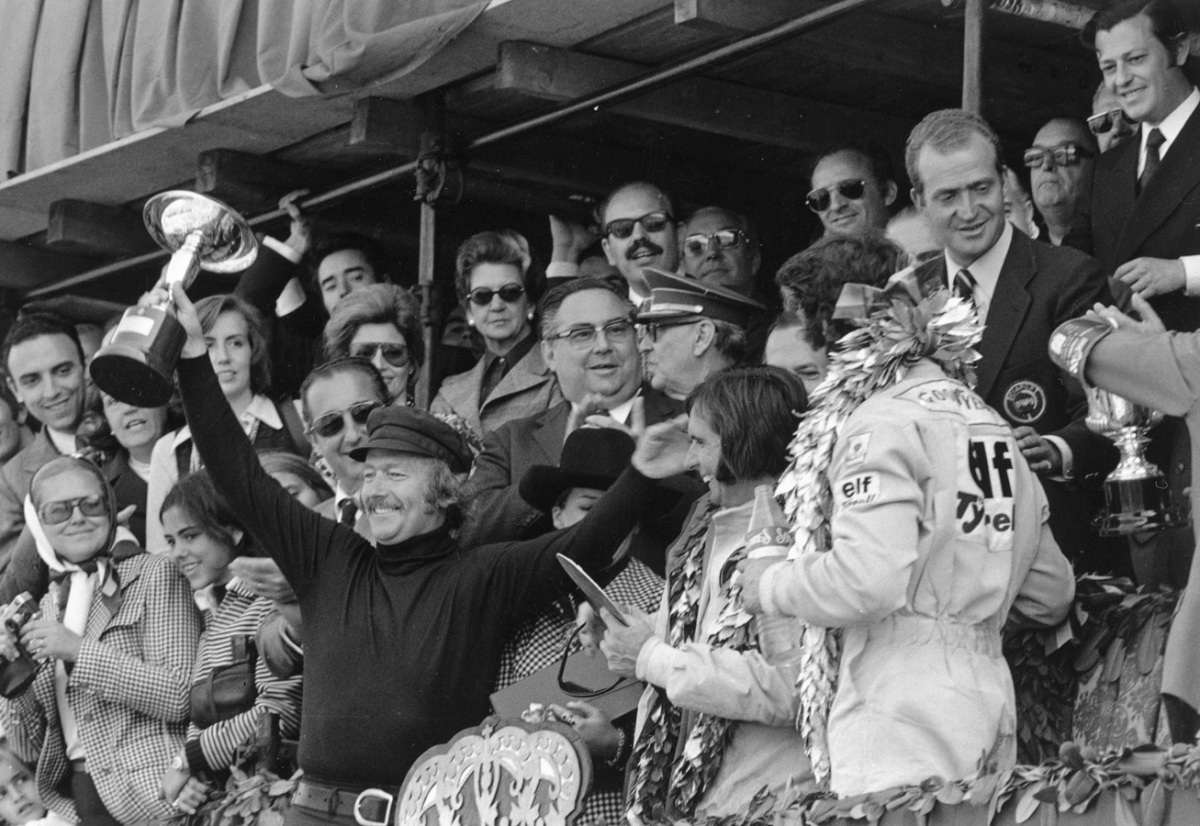 Chapman celebrando una de las 79 victorias de su equipo, aquí en Montjuich junto a Fittipaldi ante la mirada de Cevert y detrás de ellos el entonces príncipe Juan Carlos de Borbón.