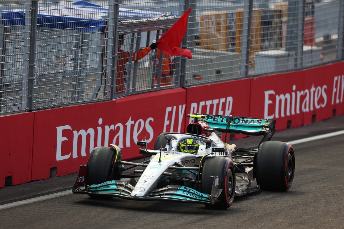 Hamilton pasa frente a un comisario que agita la única bandera roja que hubo en PL1. (Lionel Ng)