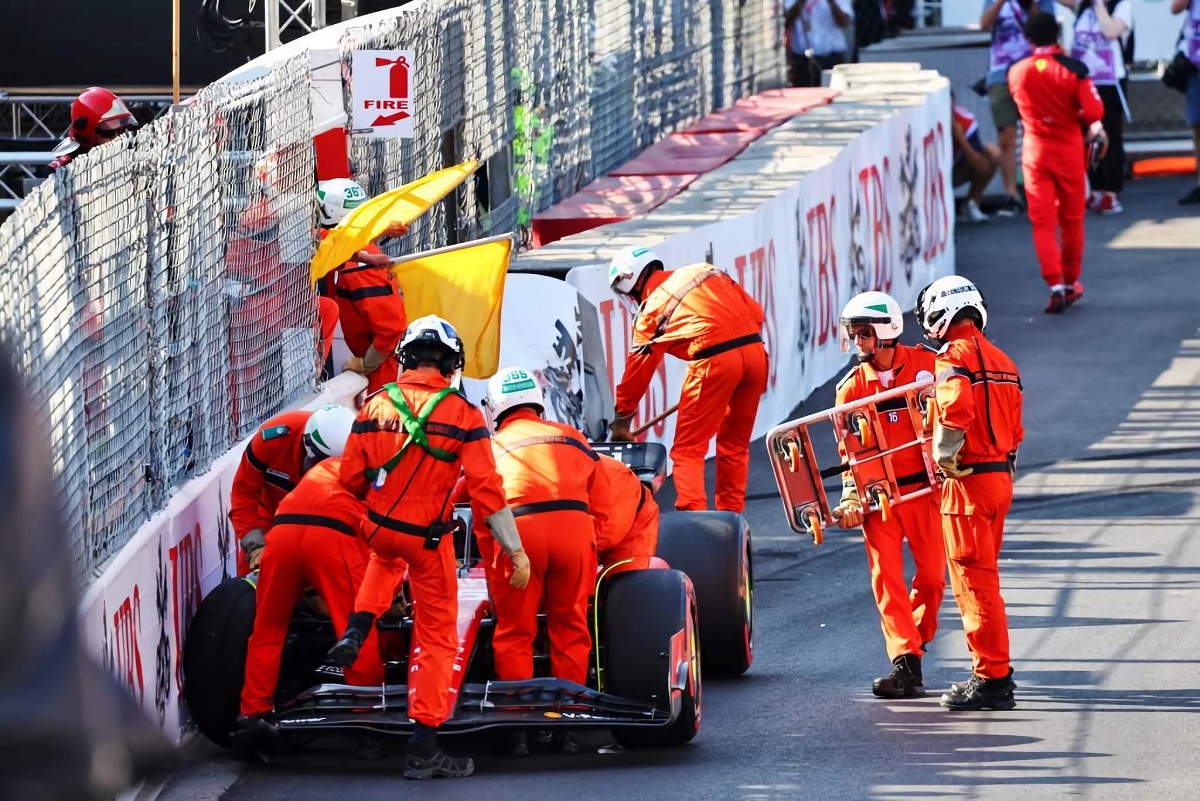 Los comisarios trabajan para retirar la Ferrari de Sainz después del accidente en la Piscina. (XPB Images)