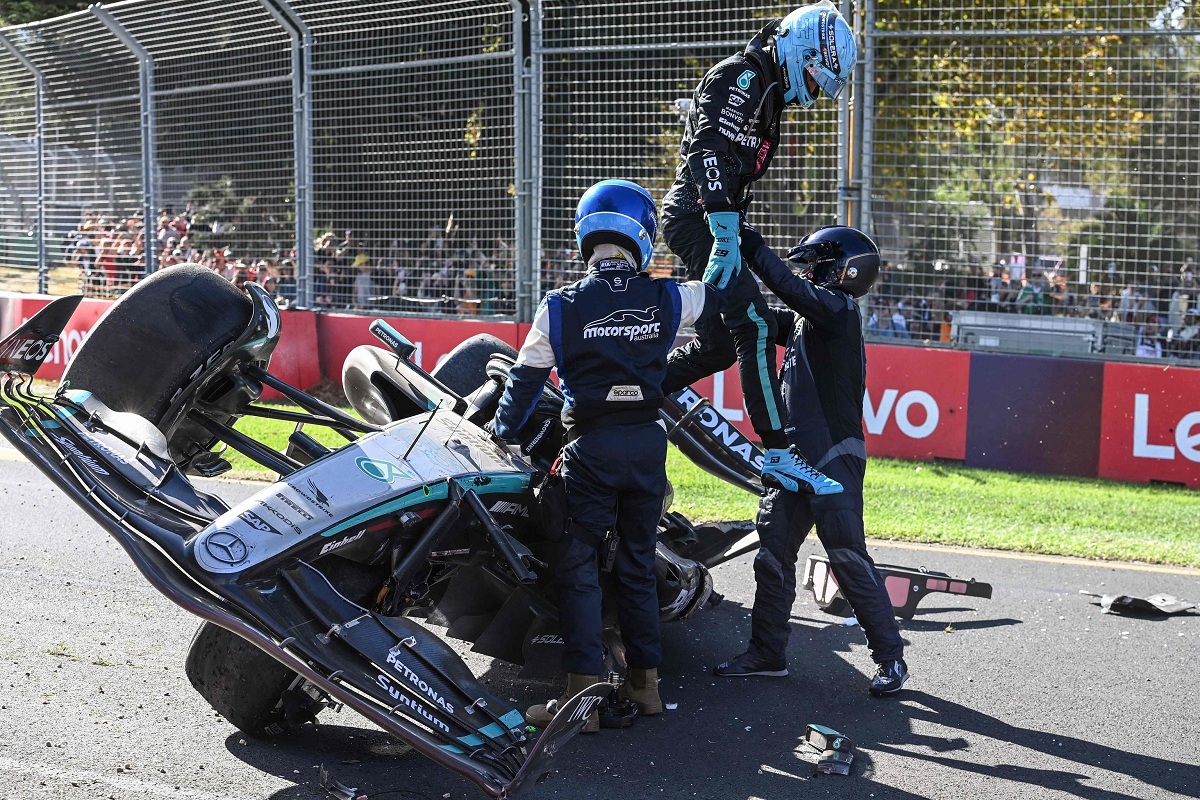 Los oficiales de pista ayudan a salir a Russell del Mercedes. (AFP) 